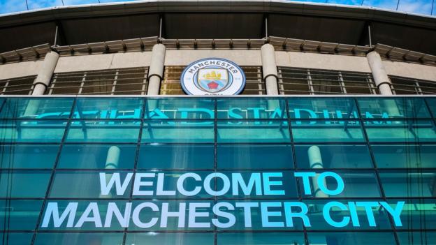 A picture of the outside of the Etihad Stadium and the words "Welcome to Manchester City"